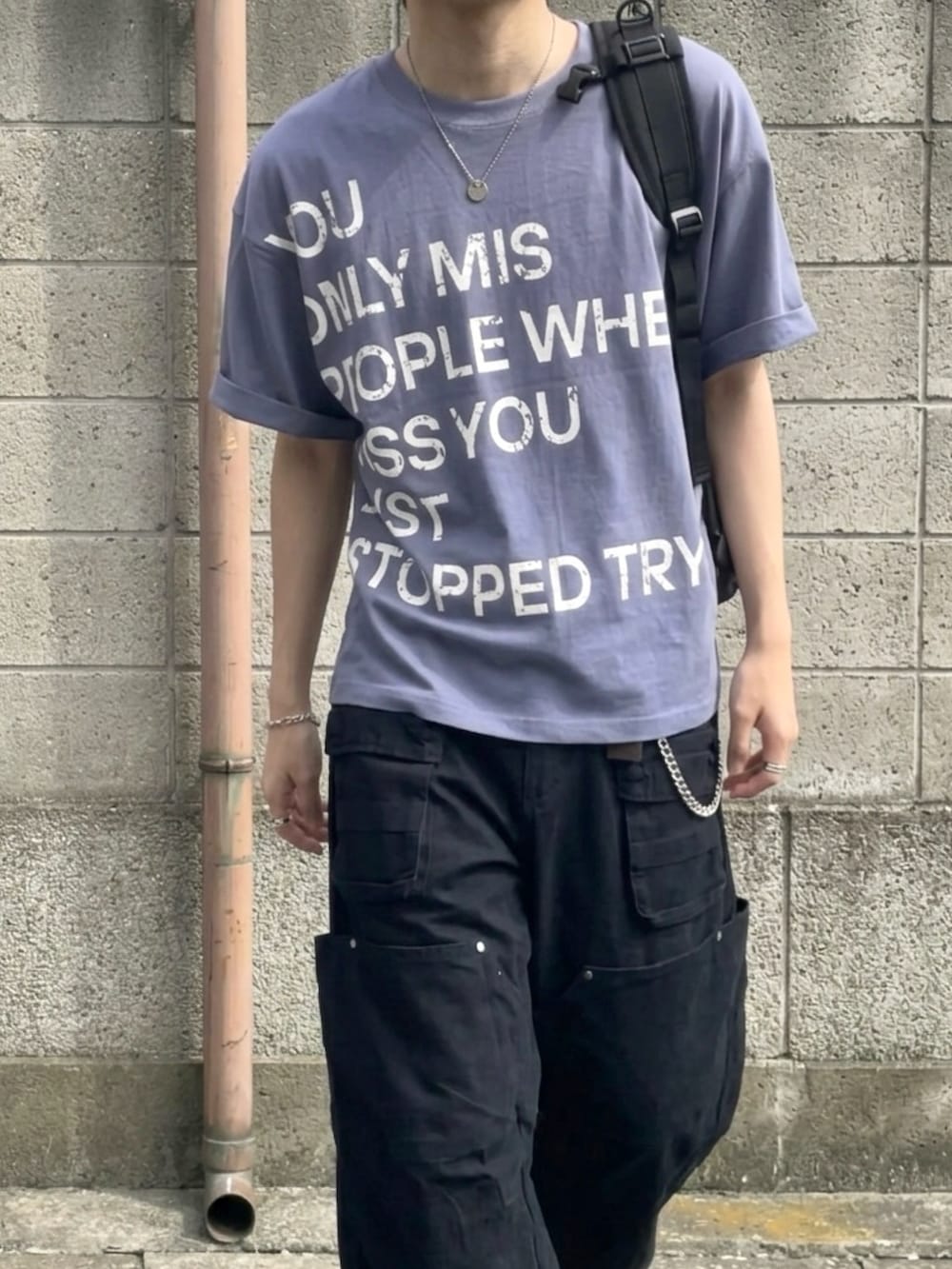 グレー系のスニーカー、ブルー系のTシャツ/カットソー、グリーン系のカーゴパンツを着用したメンズの夏コーディネートの4枚目の写真
