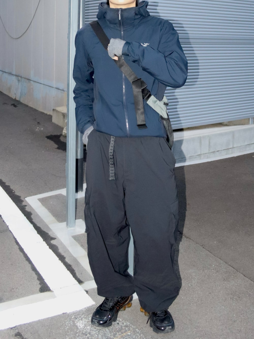 ブラック系のカーゴパンツ、グレー系のショルダーバッグ、ブラック系のスニーカーを着用したメンズの冬コーディネートの3枚目の写真