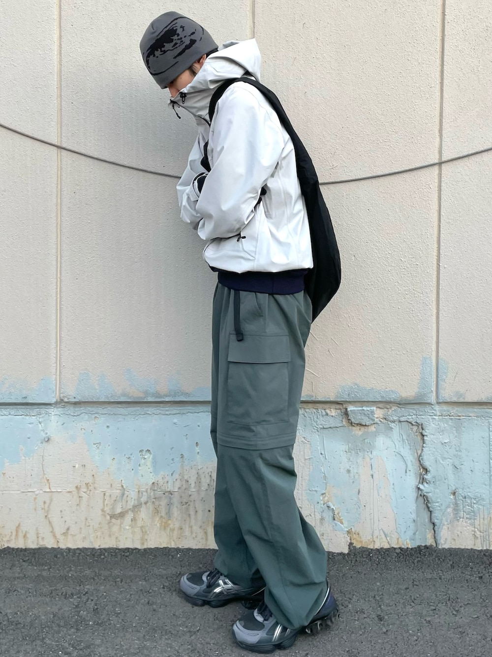 ブルー系のスウェット、ブラック系のショルダーバッグ、グレー系のスニーカーを着用したメンズの冬コーディネートの2枚目の写真