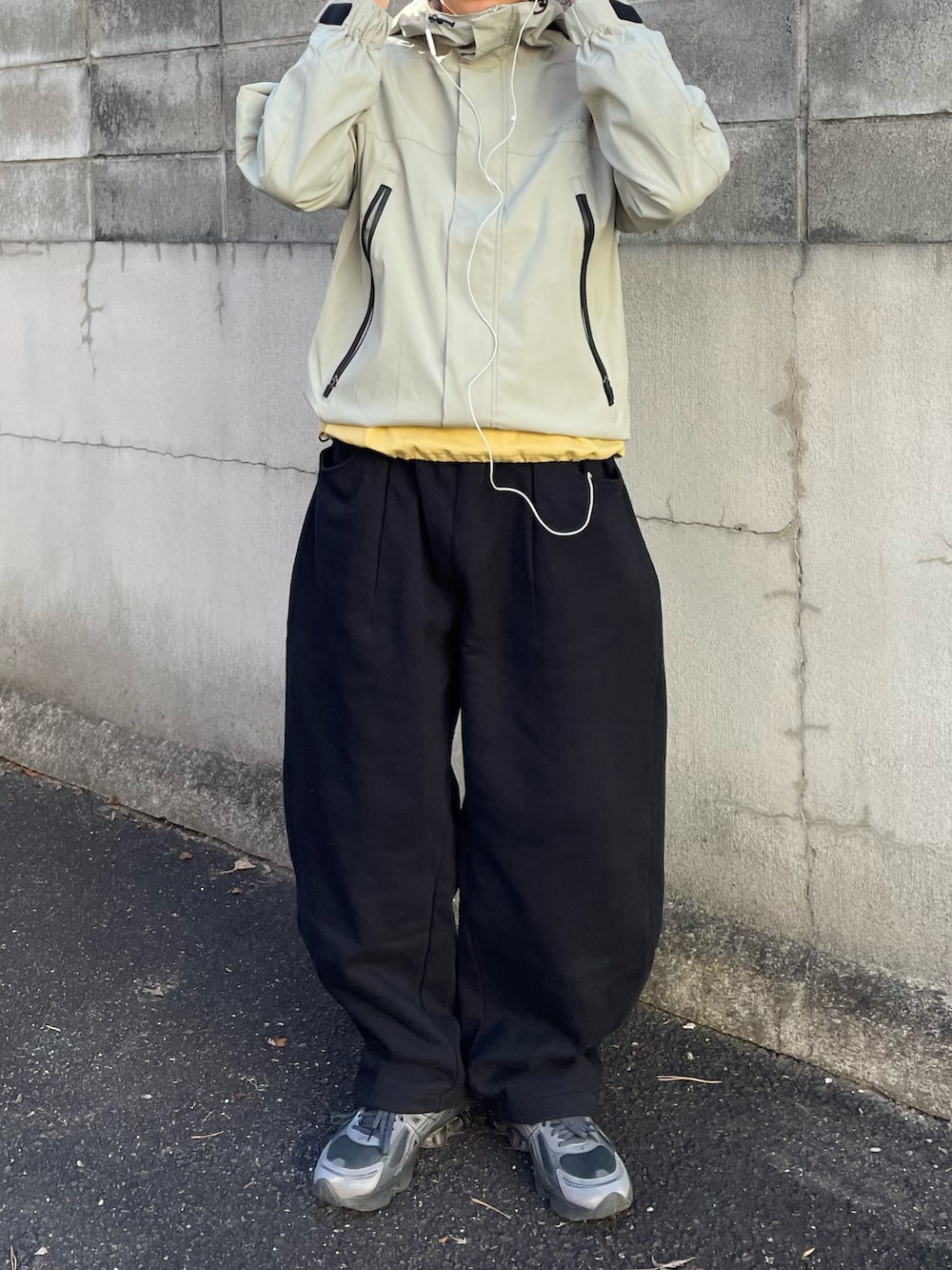 グリーン系のマウンテンパーカー、ブラック系のスウェットパンツ、イエロー系のTシャツ/カットソーを着用したメンズの春コーディネートの4枚目の写真