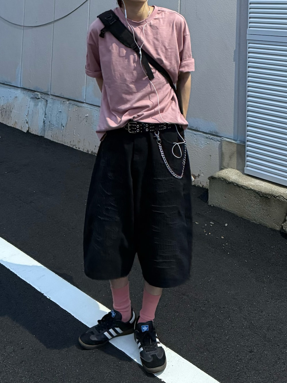 ピンク系のTシャツ/カットソー、ブラック系のスニーカー、ブラック系のデニムパンツを着用したメンズの夏コーディネートの3枚目の写真