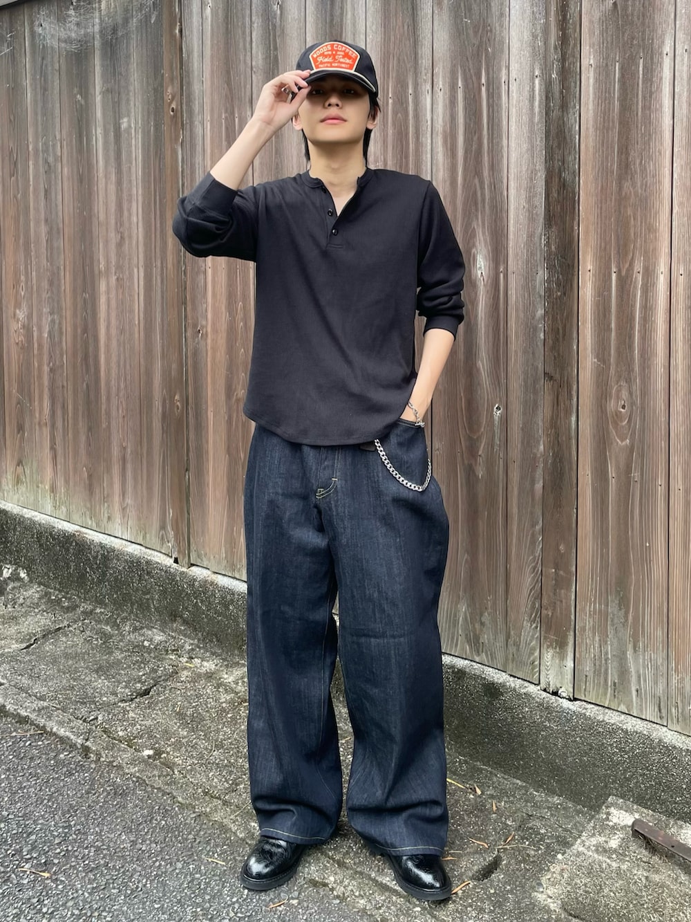 ブラック系のTシャツ/カットソー、ブルー系のデニムパンツ、ブラック系のドレスシューズを着用したメンズの秋コーディネートの2枚目の写真