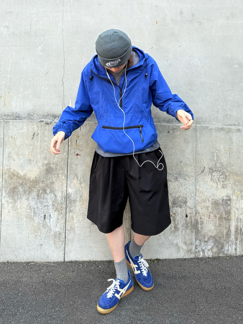 ブルー系のナイロンジャケット、ブラック系のカーゴパンツ、ブルー系のスニーカーを着用したメンズの夏コーディネートの3枚目の写真