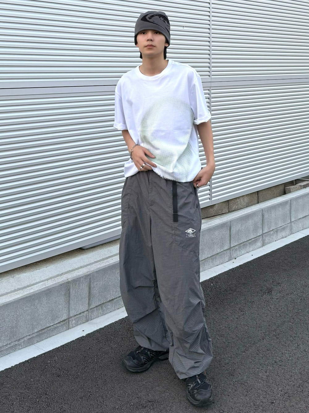 グレー系のカーゴパンツ、ホワイト系のTシャツ/カットソー、ブラック系のスニーカーを着用したメンズの夏コーディネートの2枚目の写真