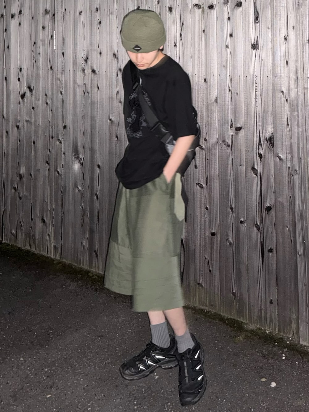 グレー系のショルダーバッグ、ブラック系のTシャツ/カットソー、グリーン系のパンツを着用したメンズの夏コーディネートの2枚目の写真