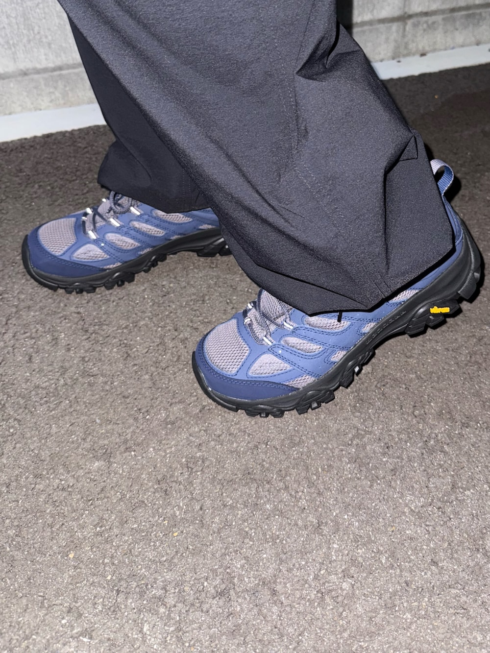 グレー系のスニーカー、ブルー系のマウンテンパーカー、グリーン系のカーゴパンツを着用したメンズの秋コーディネートの4枚目の写真