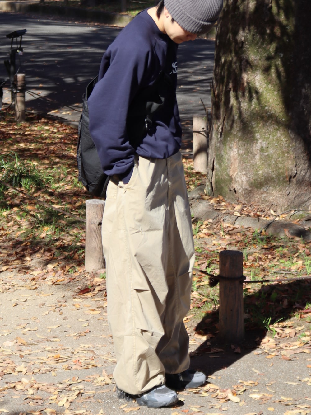 ベージュ系のカーゴパンツ、ブルー系のスウェット、ブラック系のショルダーバッグを着用したメンズの秋コーディネートの2枚目の写真