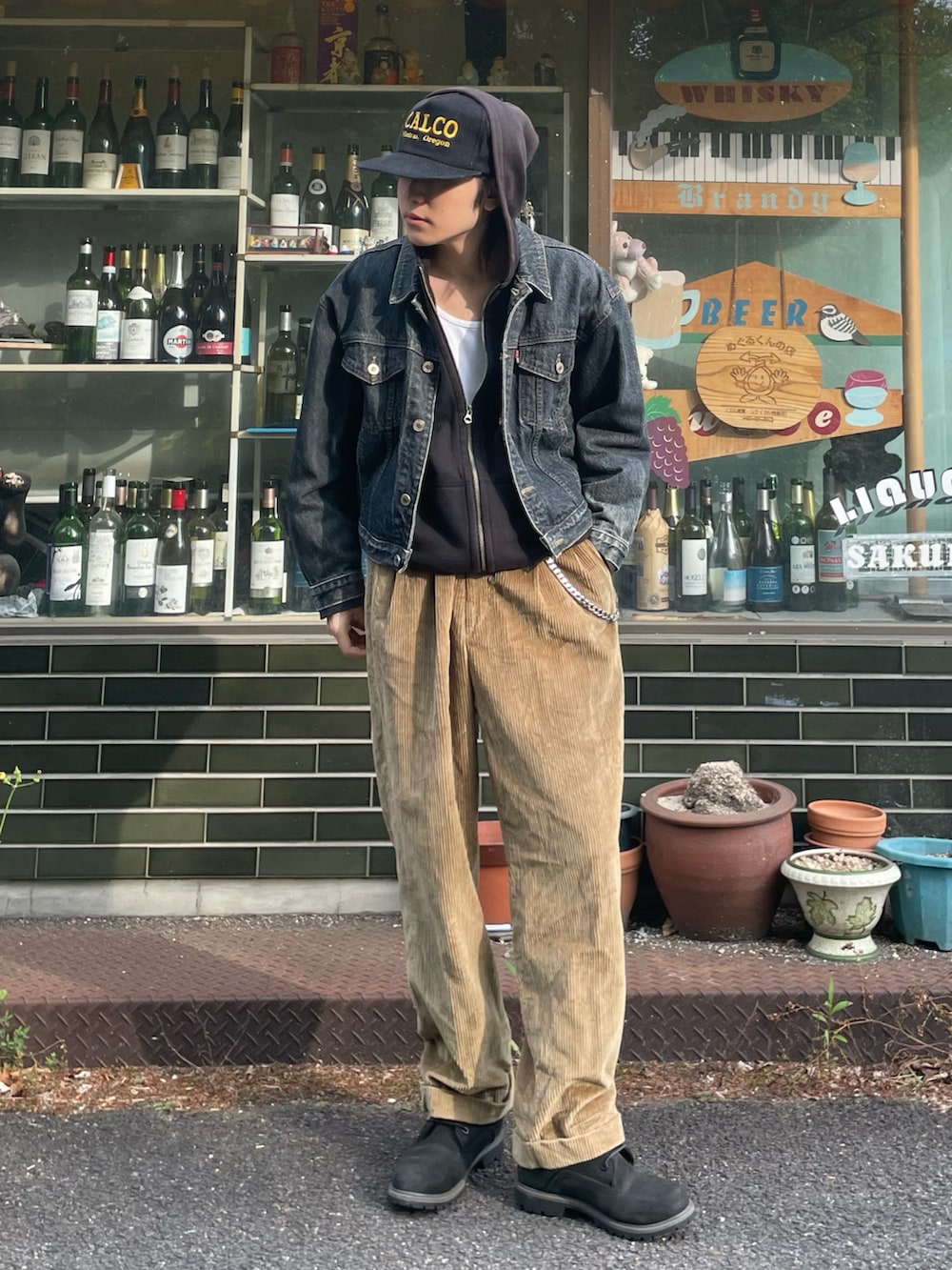 ブラック系のデニムジャケット、ブラック系のパーカー、ベージュ系のその他パンツを着用したメンズの春コーディネートの4枚目の写真