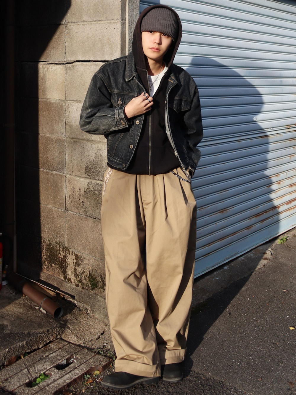 ホワイト系のTシャツ/カットソー、ブラック系のブーツ、ベージュ系のチノパンツを着用したメンズの秋コーディネートの2枚目の写真