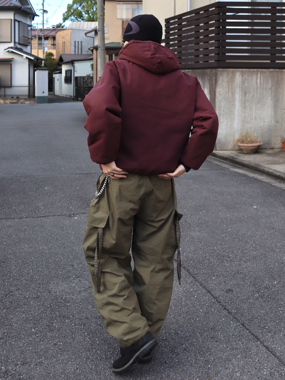 グリーン系のカーゴパンツ、ブラック系のブーツ、レッド系のジャケット/アウターを着用したメンズの秋コーディネートの4枚目の写真