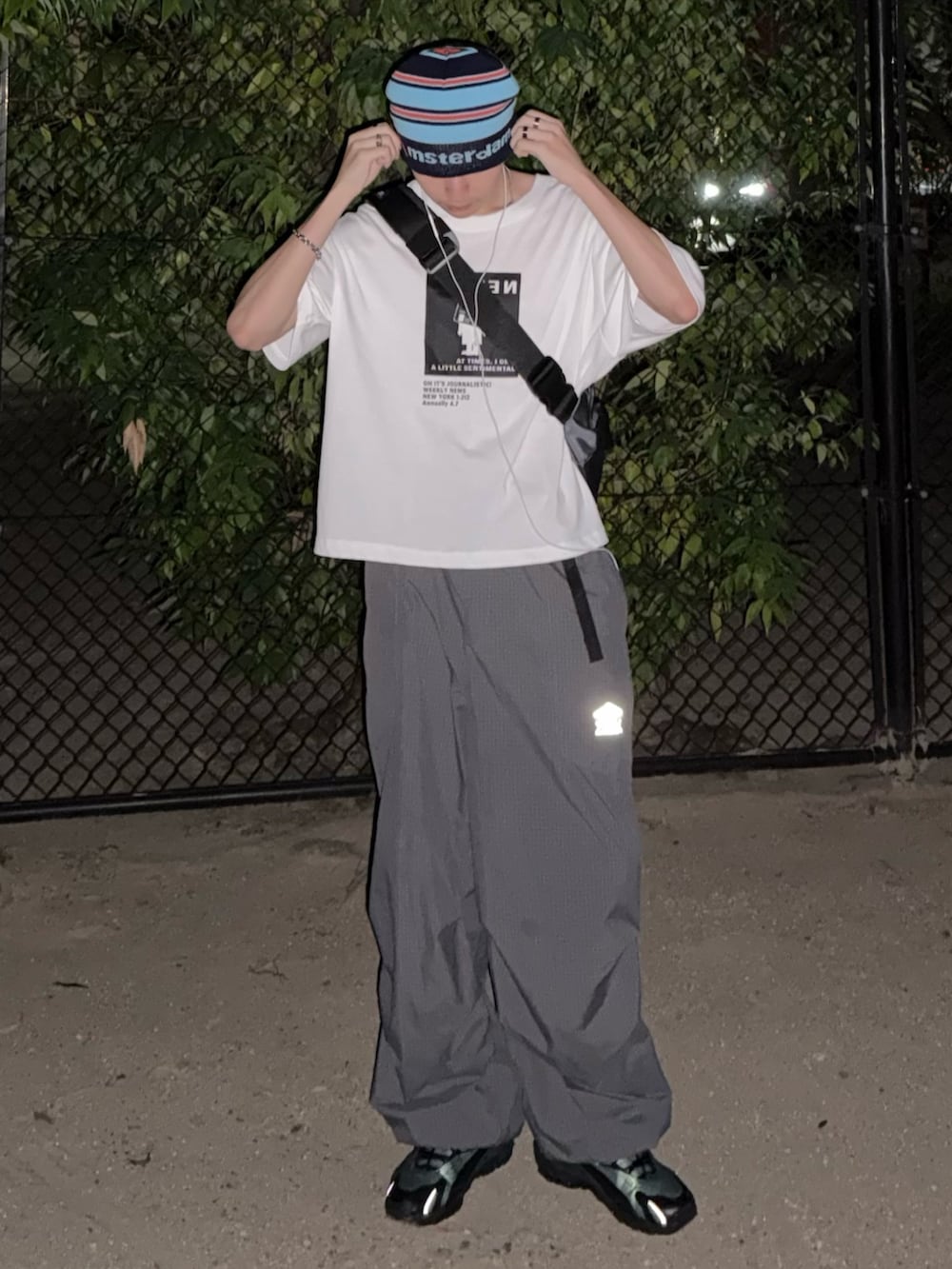 ブラック系のスニーカー、グレー系のショルダーバッグ、グレー系のカーゴパンツを着用したメンズの夏コーディネートの3枚目の写真