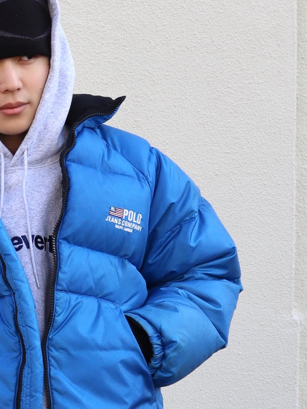 グレー系のパーカー、ブラック系のカーゴパンツ、ブラック系のスニーカーを着用したメンズの冬コーディネートの3枚目の写真