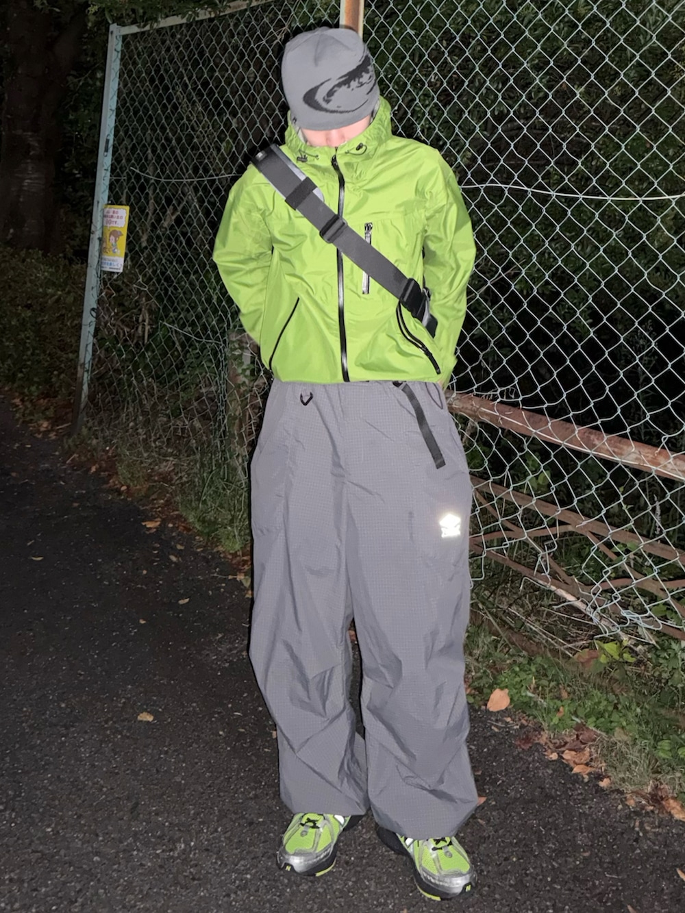 グレー系のカーゴパンツ、グリーン系のスニーカー、グリーン系のマウンテンパーカーを着用したメンズの秋コーディネートの2枚目の写真