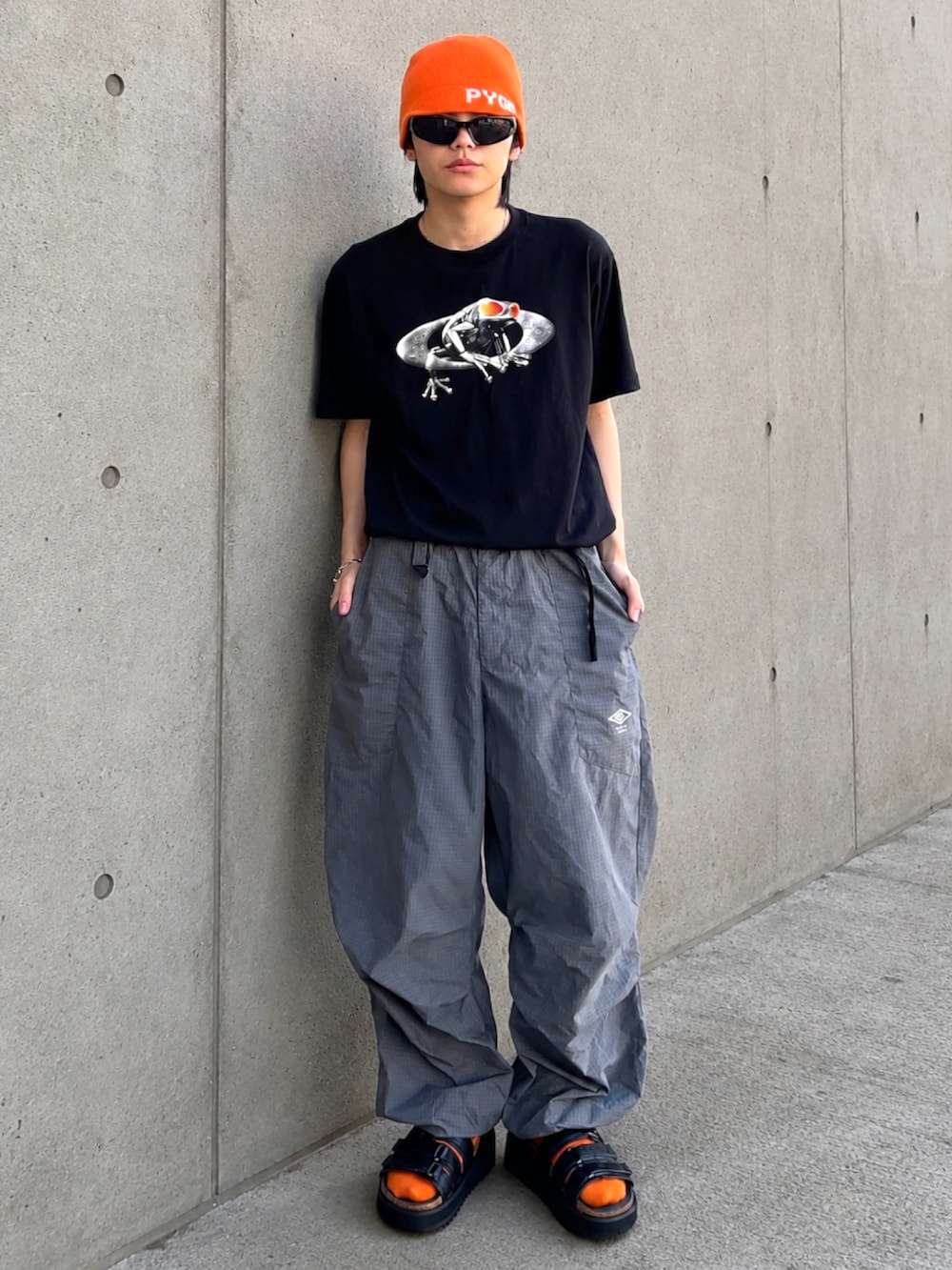 ブラック系のTシャツ/カットソー、ブラック系のサンダル、グレー系のカーゴパンツを着用したメンズの夏コーディネートの2枚目の写真
