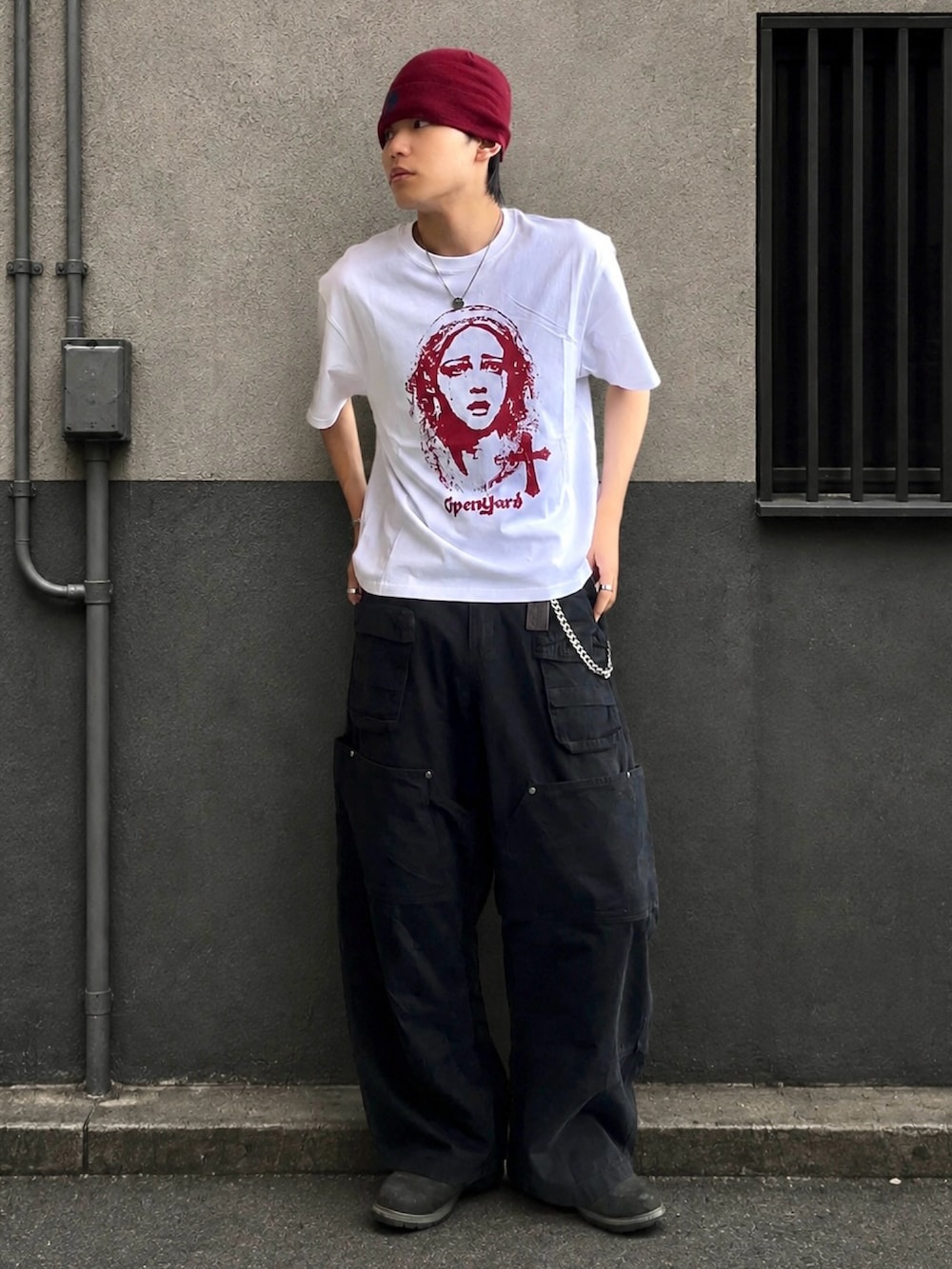 ブラック系のブーツ、ホワイト系のTシャツ/カットソー、グリーン系のカーゴパンツを着用したメンズの夏コーディネートの2枚目の写真