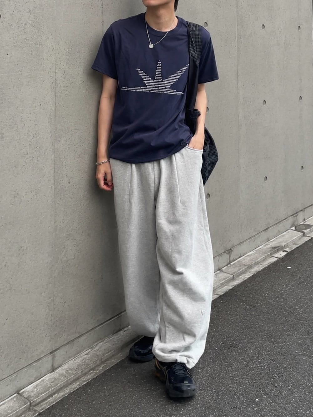 グレー系のスウェットパンツ、ブルー系のTシャツ/カットソー、ブラック系のショルダーバッグを着用したメンズの夏コーディネートの3枚目の写真