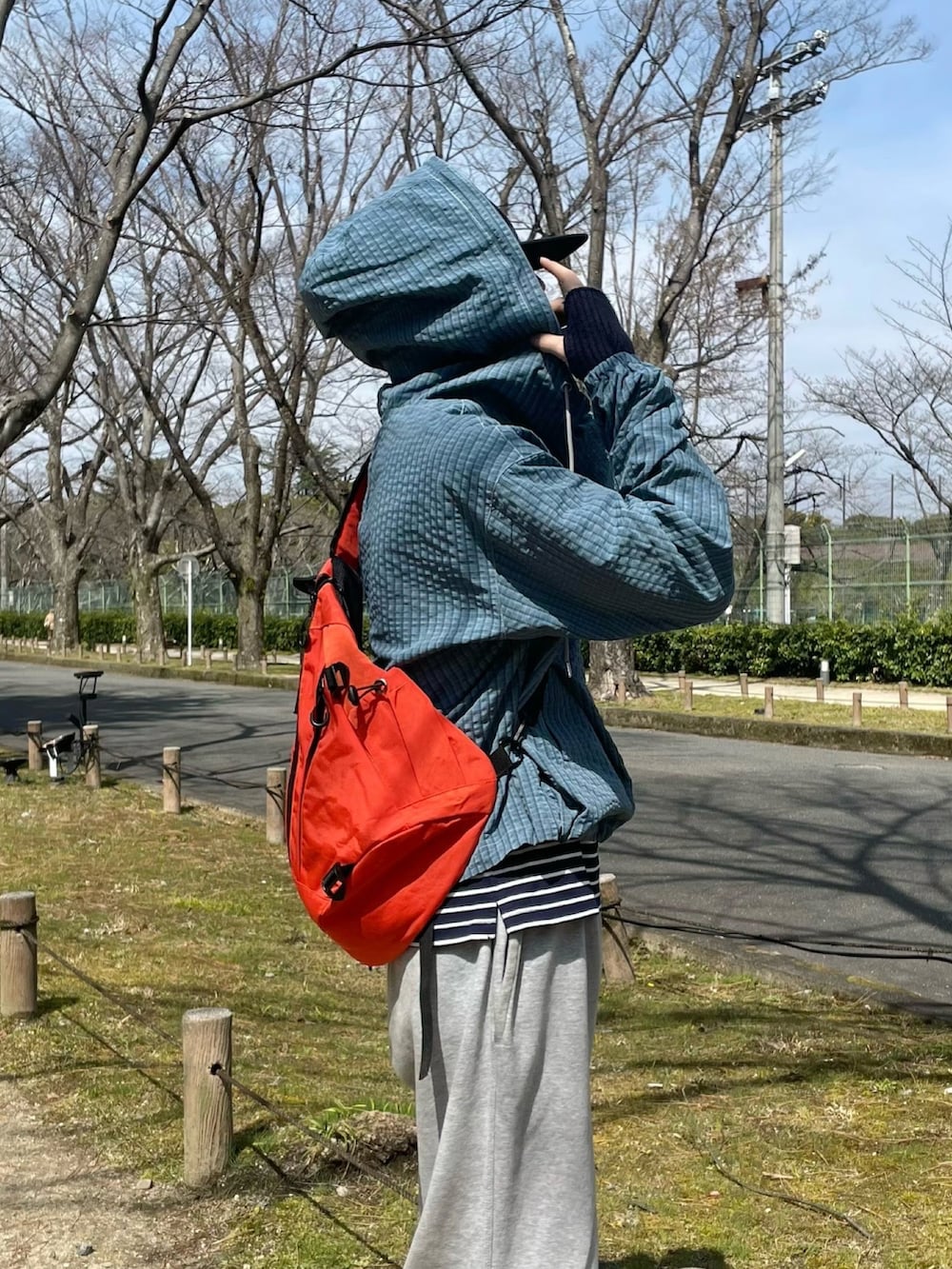 グレー系のスニーカー、ホワイト系のTシャツ/カットソー、ブルー系のパーカーを着用したメンズの春コーディネートの3枚目の写真