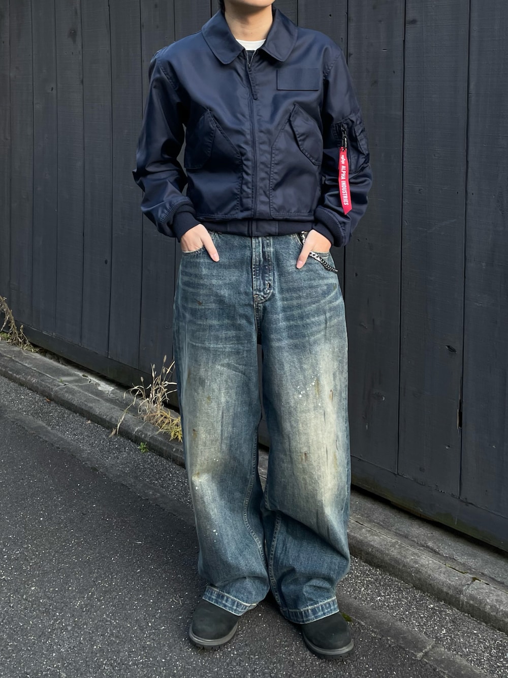 ブラック系のブーツ、ブルー系のデニムパンツ、ブルー系のミリタリージャケットを着用したメンズの春コーディネートの3枚目の写真