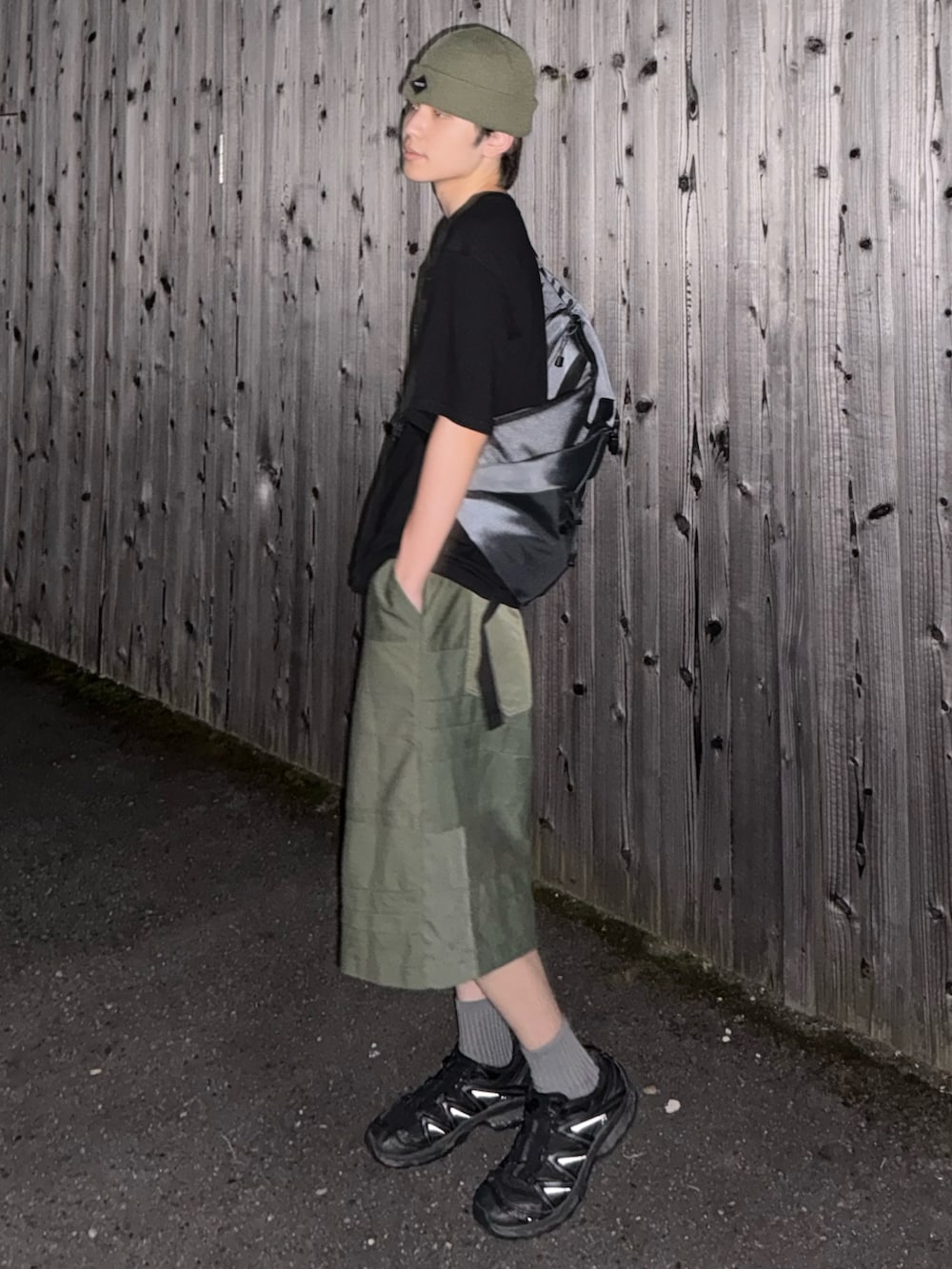 グレー系のショルダーバッグ、ブラック系のTシャツ/カットソー、グリーン系のパンツを着用したメンズの夏コーディネートの3枚目の写真