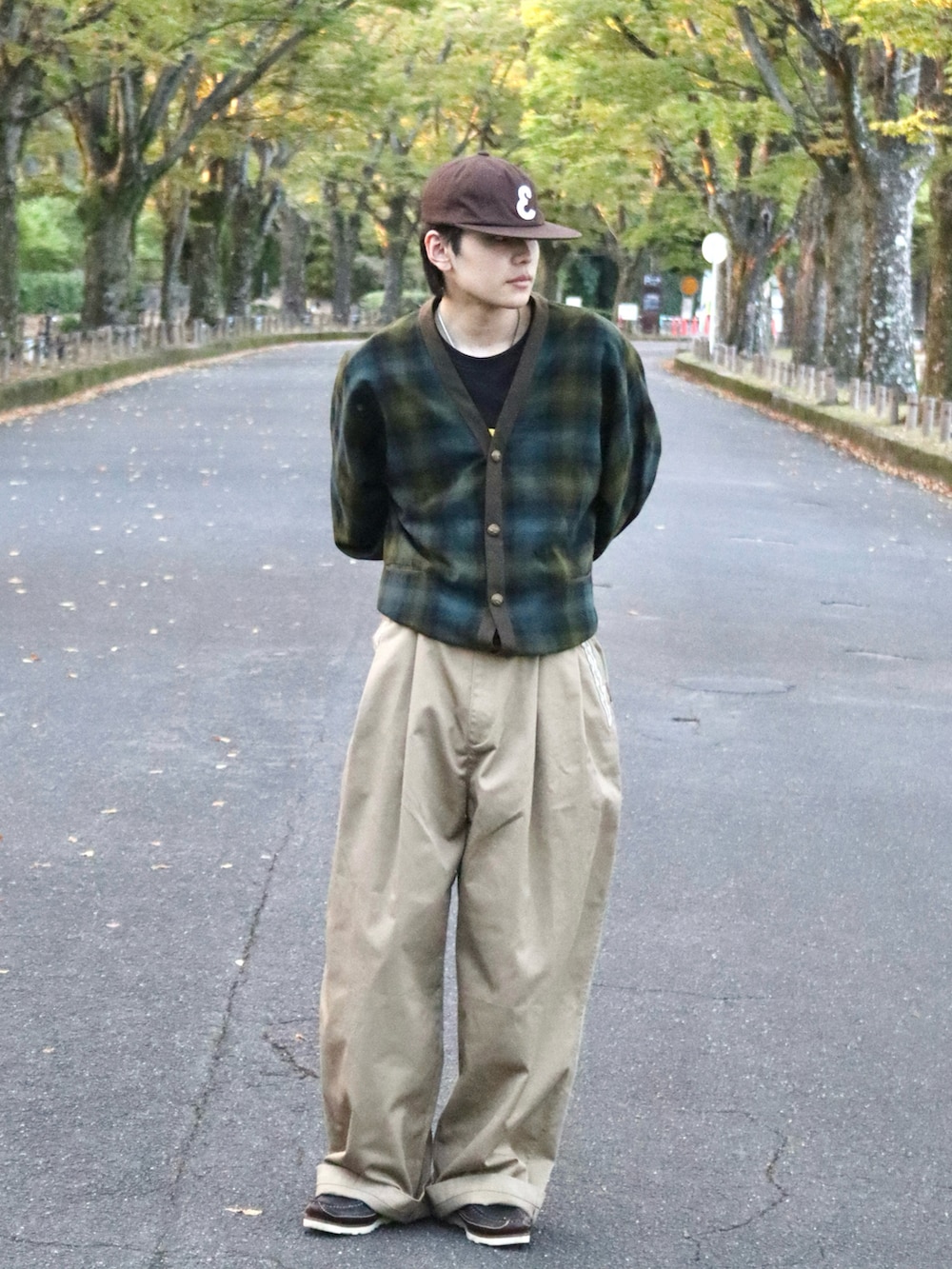 ベージュ系のチノパンツ、ブラック系のTシャツ/カットソー、グリーン系のカーディガン/ボレロを着用したメンズの秋コーディネートの3枚目の写真