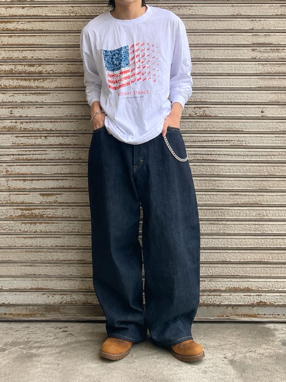 ブルー系のデニムパンツ、ホワイト系のTシャツ/カットソー、ブラウン系のブーツを着用したメンズの夏コーディネートの3枚目の写真