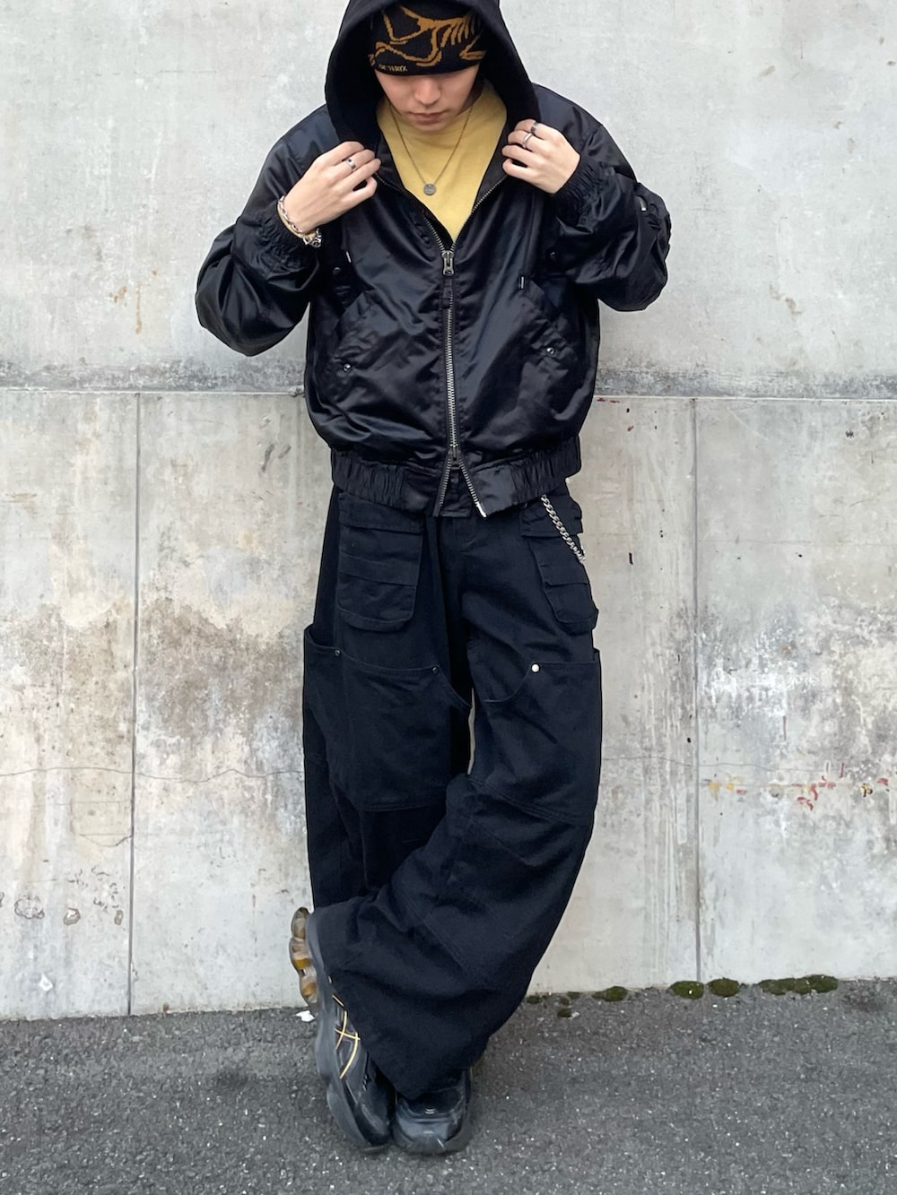 ブラック系のブルゾン、イエロー系のTシャツ/カットソー、ブラック系のカーゴパンツを着用したメンズの秋コーディネートの5枚目の写真