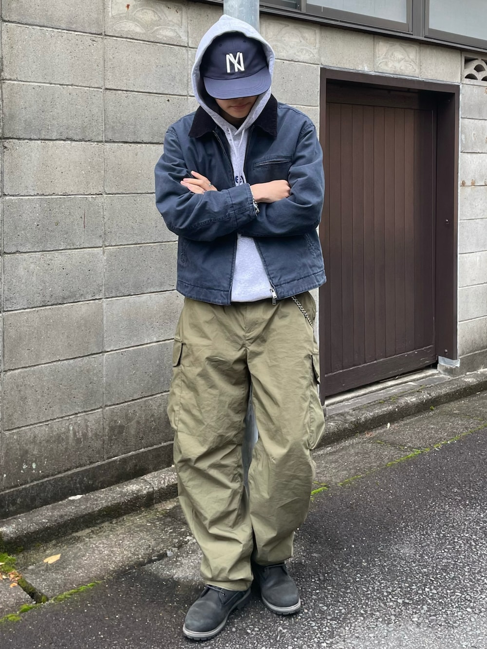 グレー系のパーカー、グリーン系のカーゴパンツ、ブラック系のブーツを着用したメンズの冬コーディネートの2枚目の写真