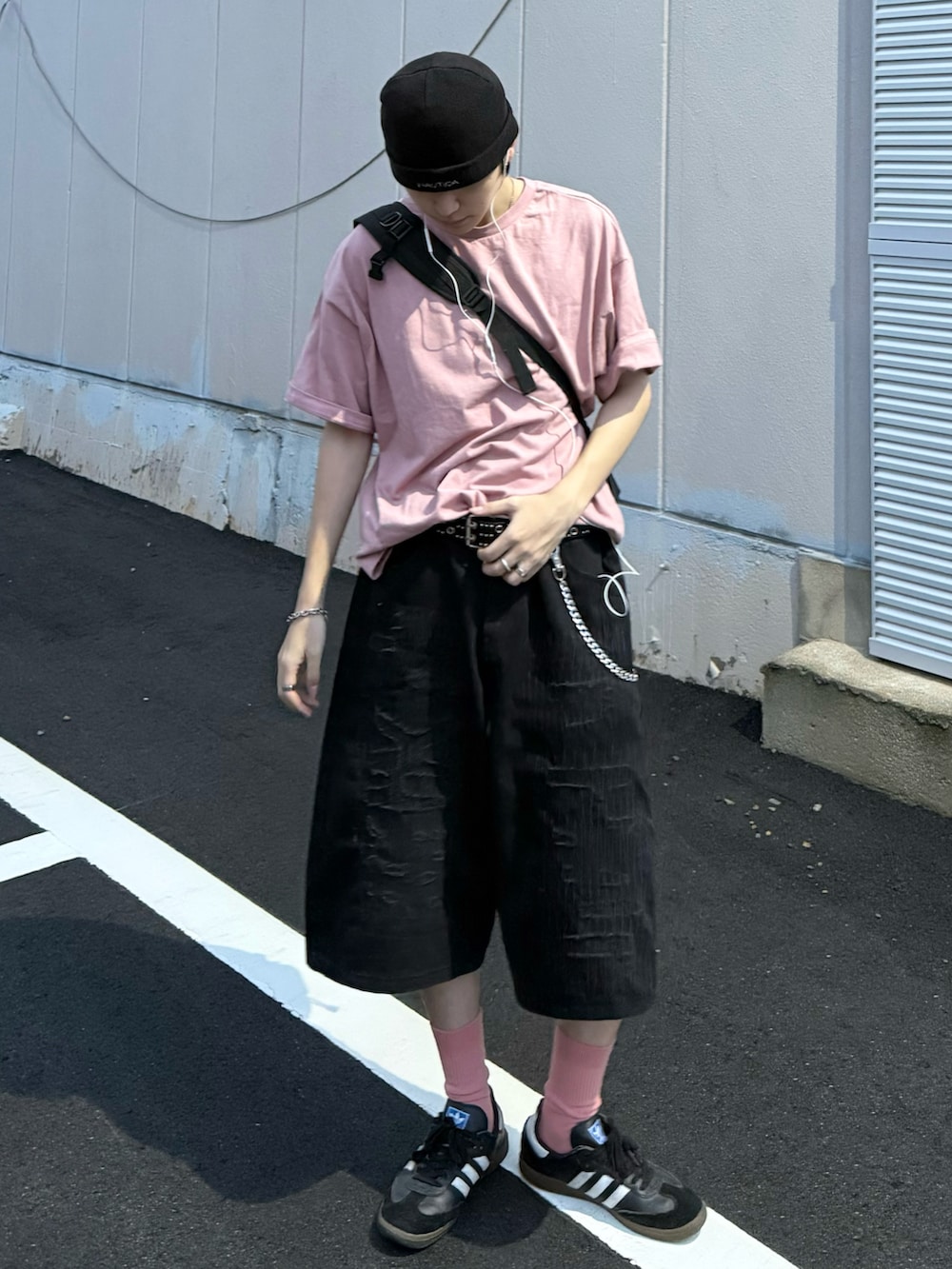 ピンク系のTシャツ/カットソー、ブラック系のスニーカー、ブラック系のデニムパンツを着用したメンズの夏コーディネートの2枚目の写真