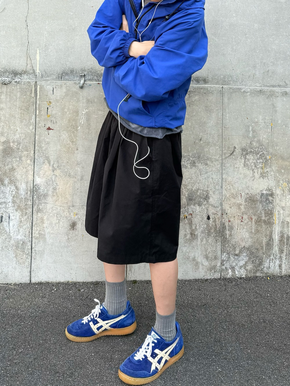 ブルー系のナイロンジャケット、ブラック系のカーゴパンツ、ブルー系のスニーカーを着用したメンズの夏コーディネートの2枚目の写真