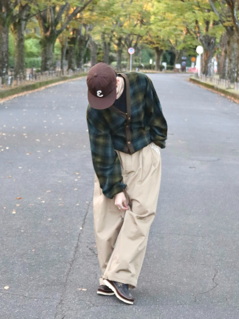 ベージュ系のチノパンツ、ブラック系のTシャツ/カットソー、グリーン系のカーディガン/ボレロを着用したメンズの秋コーディネートの4枚目の写真