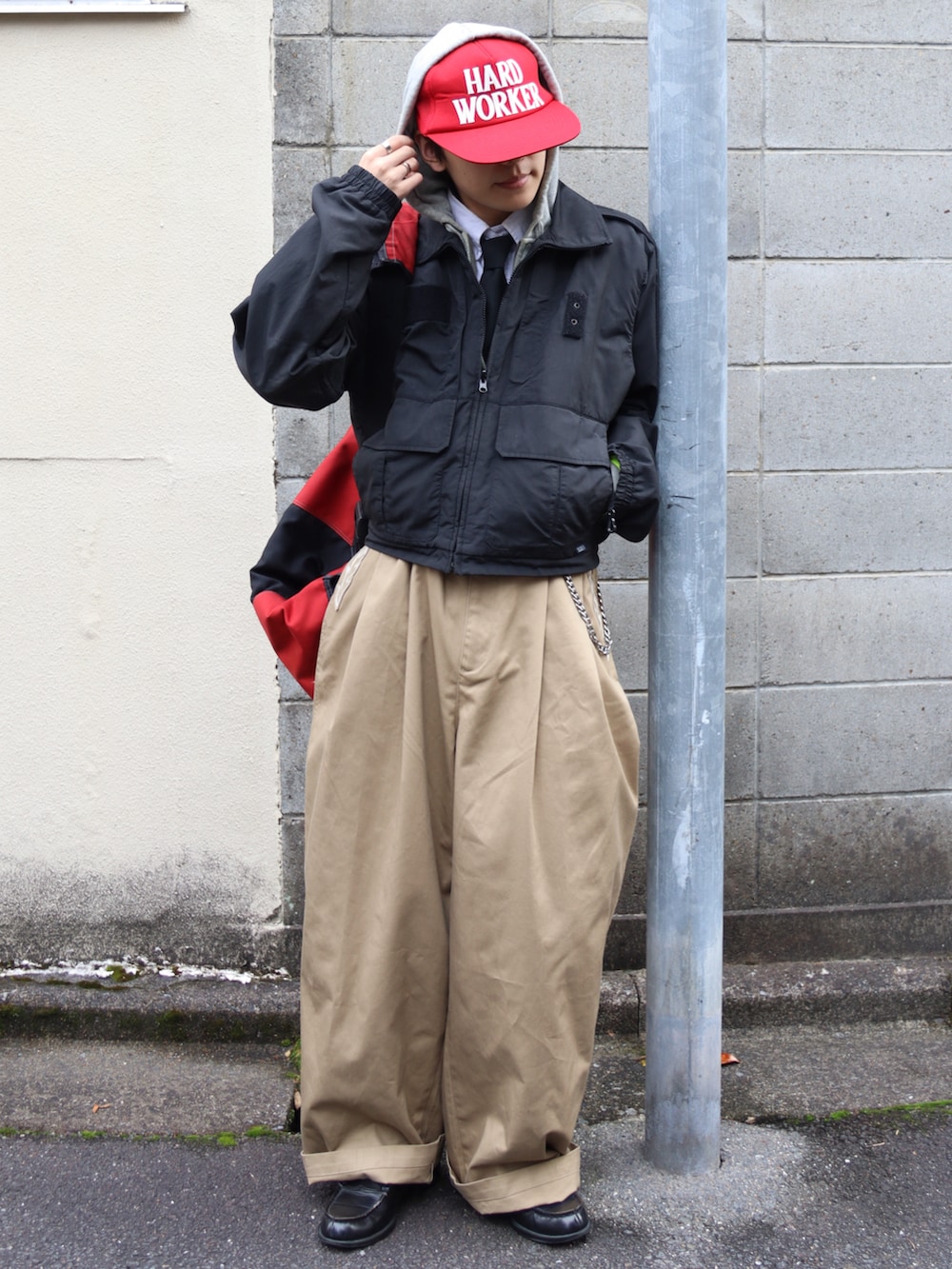 グレー系のパーカー、ブラック系のローファー、ベージュ系のチノパンツを着用したメンズの秋コーディネートの2枚目の写真