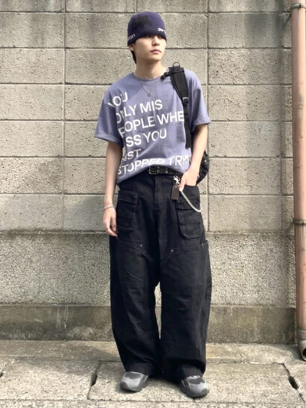 グレー系のスニーカー、ブルー系のTシャツ/カットソー、グリーン系のカーゴパンツを着用したメンズの夏コーディネートの2枚目の写真