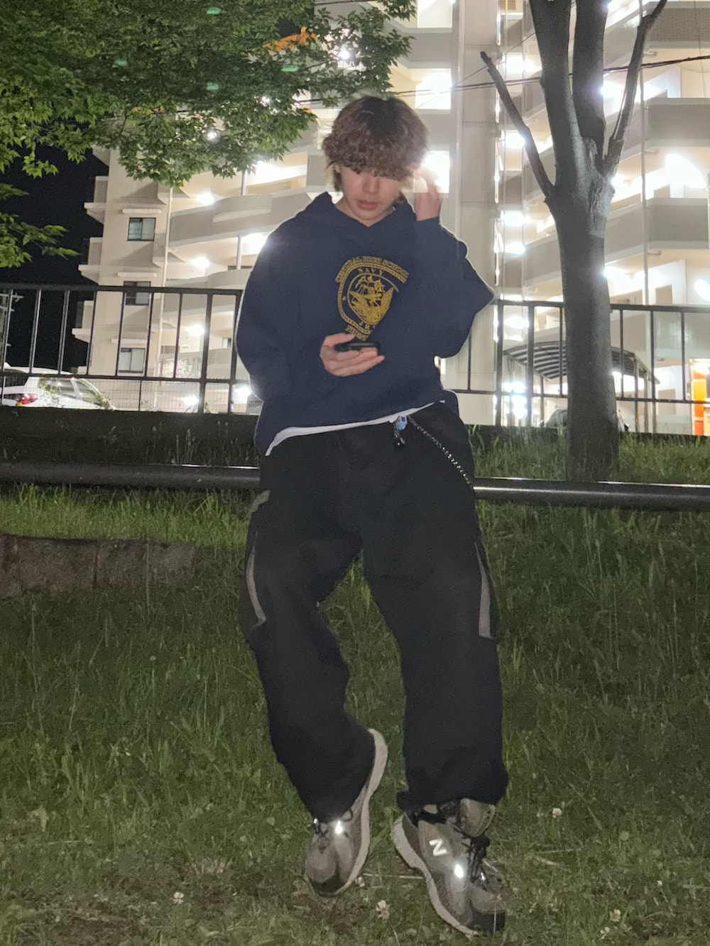 グリーン系のスニーカー、ブラック系のカーゴパンツを着用したメンズの秋コーディネートの2枚目の写真