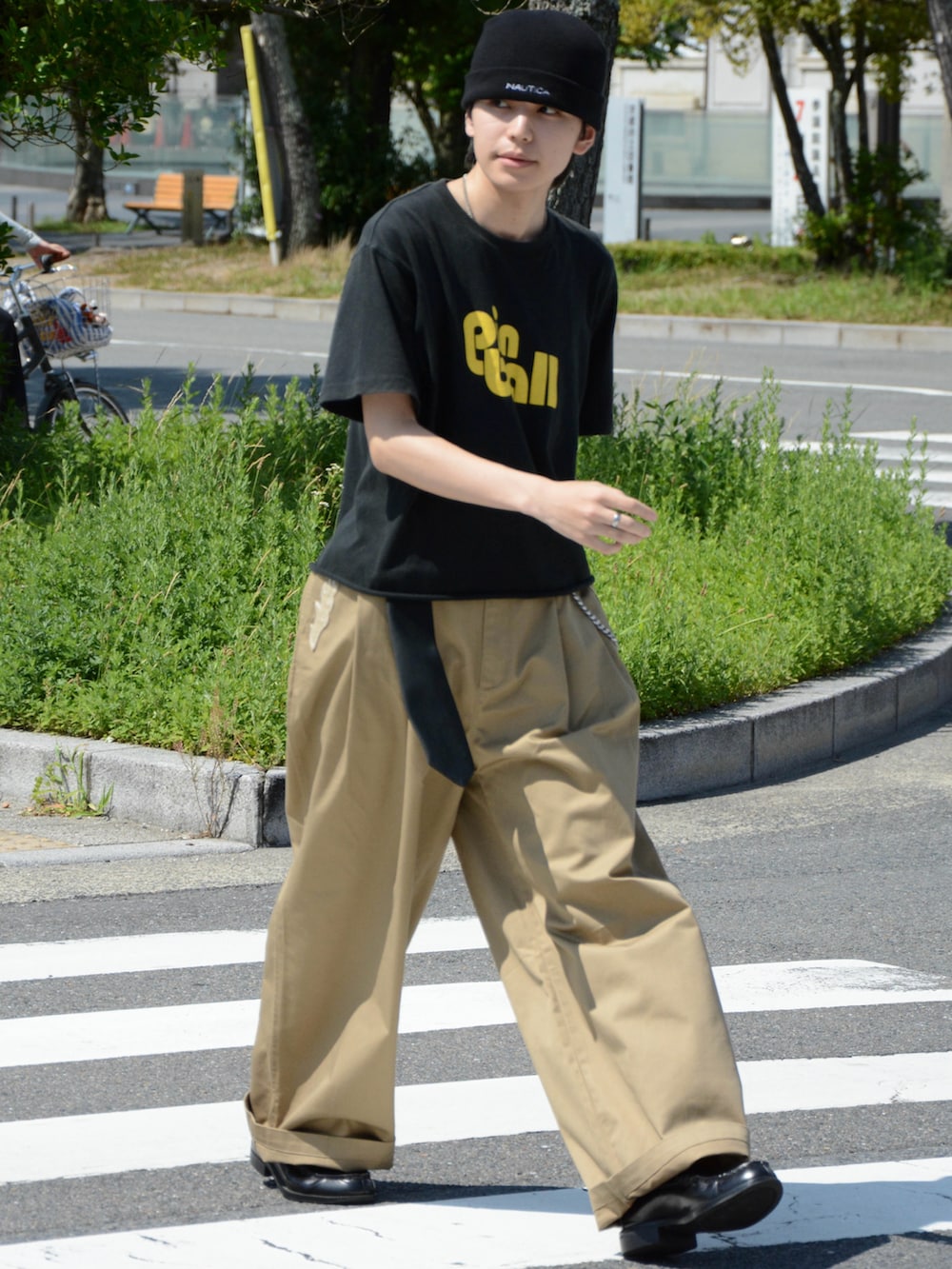 ベージュ系のチノパンツ、ブラック系のTシャツ/カットソー、ブラック系のローファーを着用したメンズの夏コーディネートの2枚目の写真