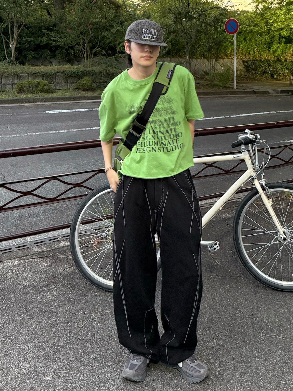 グレー系のスニーカー、グリーン系のメッセンジャーバッグを着用したメンズの夏コーディネートの2枚目の写真