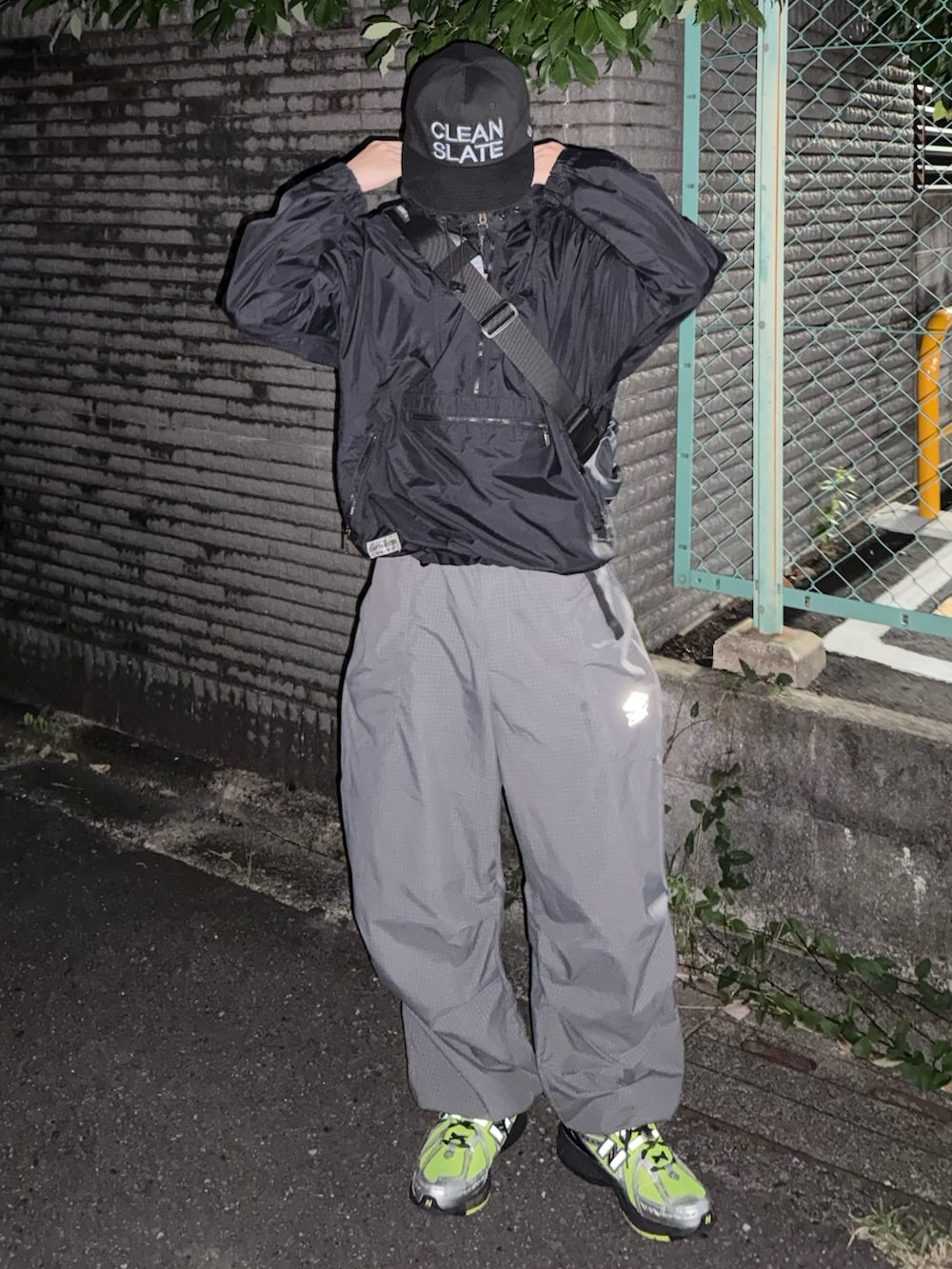 グレー系のショルダーバッグ、グレー系のカーゴパンツ、グリーン系のスニーカーを着用したメンズの冬コーディネートの2枚目の写真