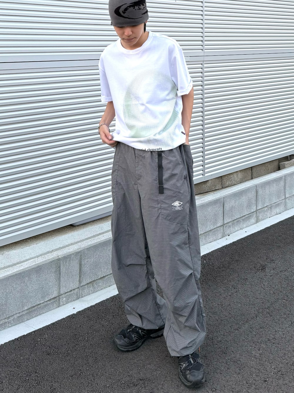 グレー系のカーゴパンツ、ホワイト系のTシャツ/カットソー、ブラック系のスニーカーを着用したメンズの夏コーディネートの3枚目の写真