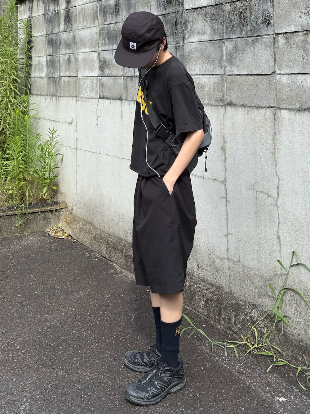 グレー系のショルダーバッグ、ブラック系のカーゴパンツ、ブラック系のTシャツ/カットソーを着用したメンズの夏コーディネートの2枚目の写真