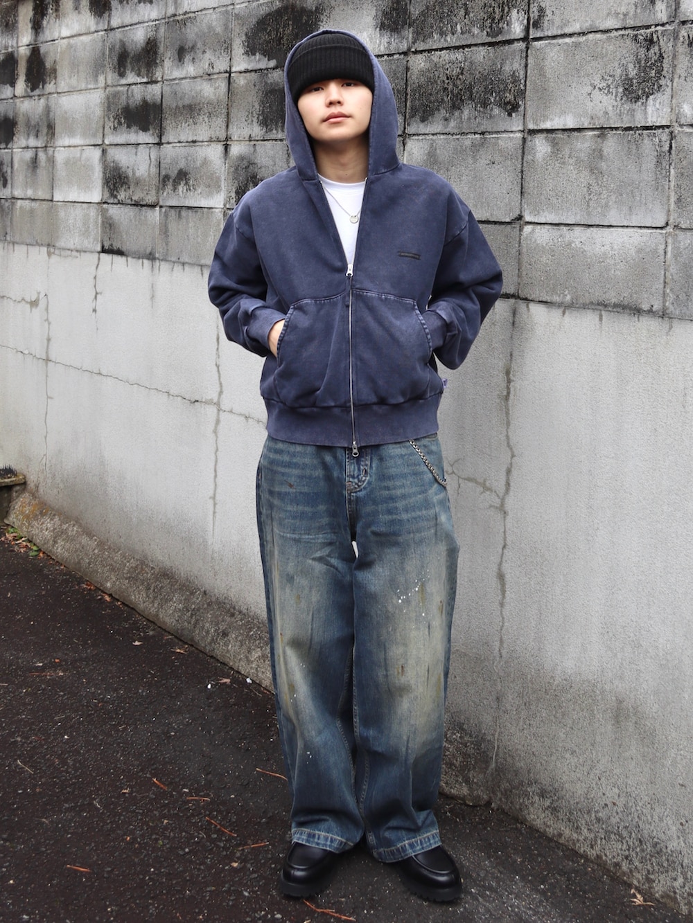 ブルー系のパーカー、ブラック系のドレスシューズ、ブルー系のデニムパンツを着用したメンズの春コーディネートの2枚目の写真