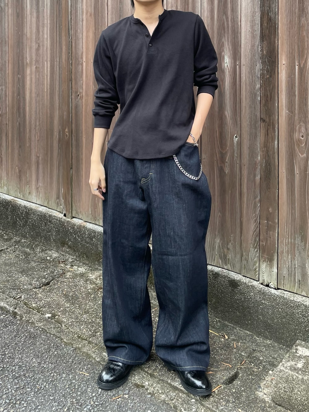 ブラック系のTシャツ/カットソー、ブルー系のデニムパンツ、ブラック系のドレスシューズを着用したメンズの秋コーディネートの3枚目の写真
