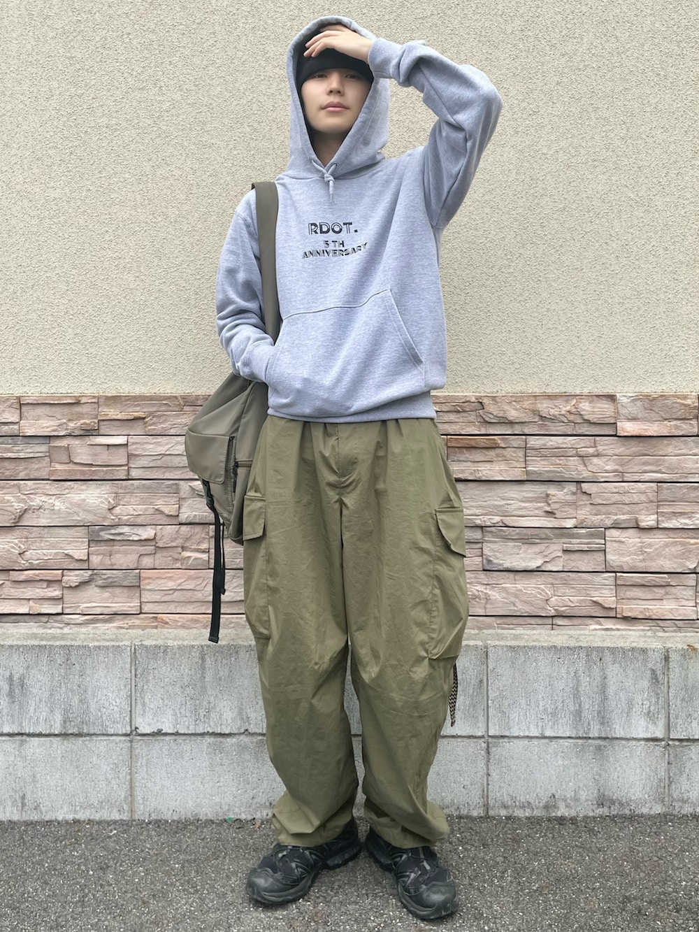グリーン系のカーゴパンツ、グリーン系のショルダーバッグ、ブラック系のスニーカーを着用したメンズの秋コーディネートの2枚目の写真