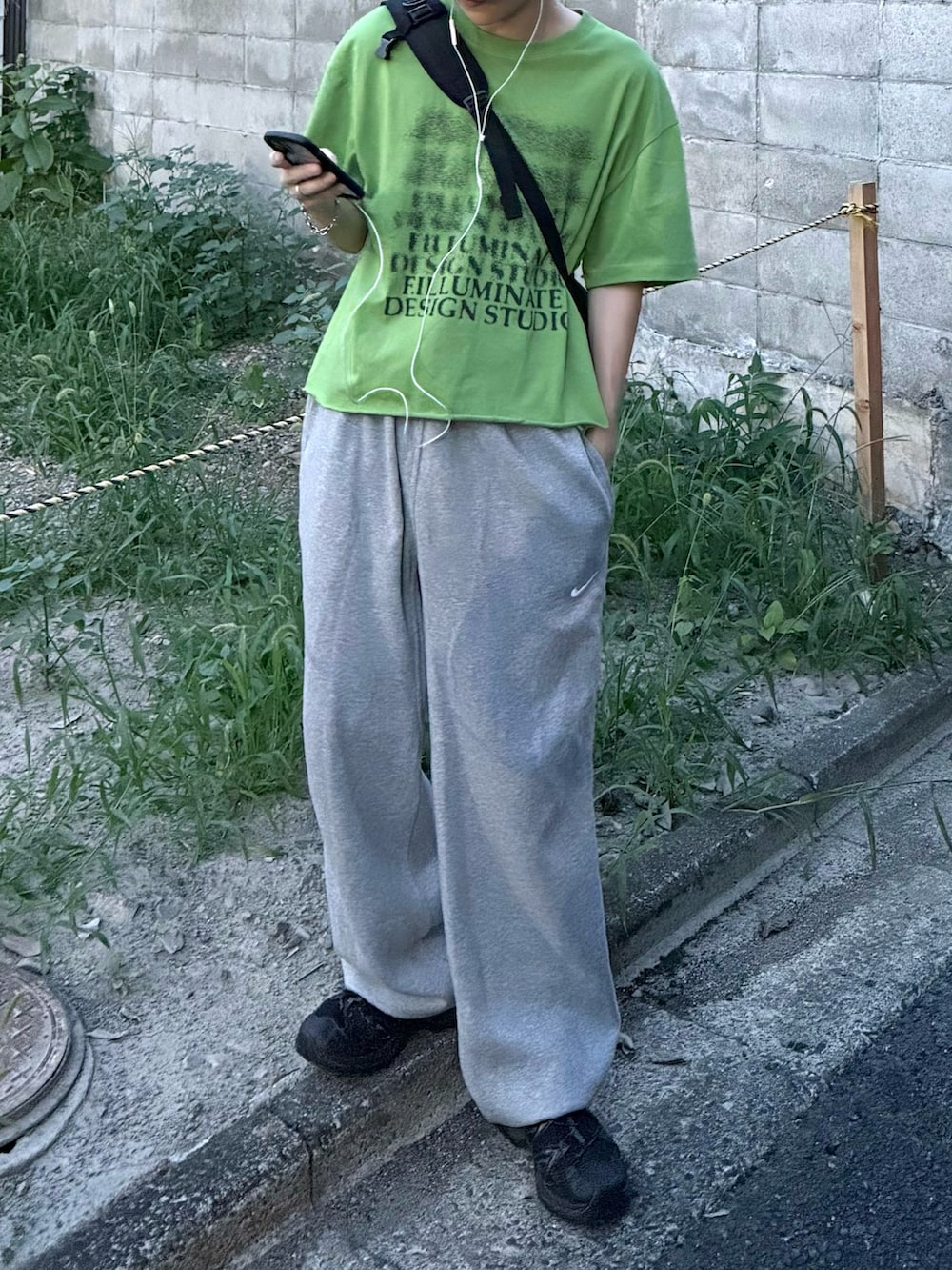 ブラック系のスニーカー、グリーン系のTシャツ/カットソー、グレー系のスウェットパンツを着用したメンズの秋コーディネートの3枚目の写真