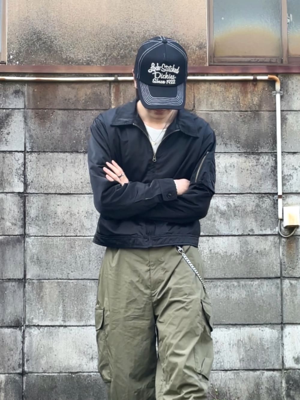 ブラック系のブーツ、ホワイト系のTシャツ/カットソー、ブラック系のミリタリージャケットを着用したメンズの春コーディネートの2枚目の写真
