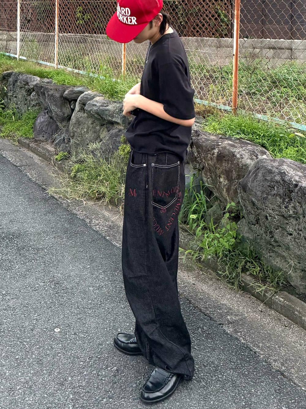 ブラック系のTシャツ/カットソー、ブラック系のデニムパンツ、ブラック系のローファーを着用したメンズの秋コーディネートの4枚目の写真