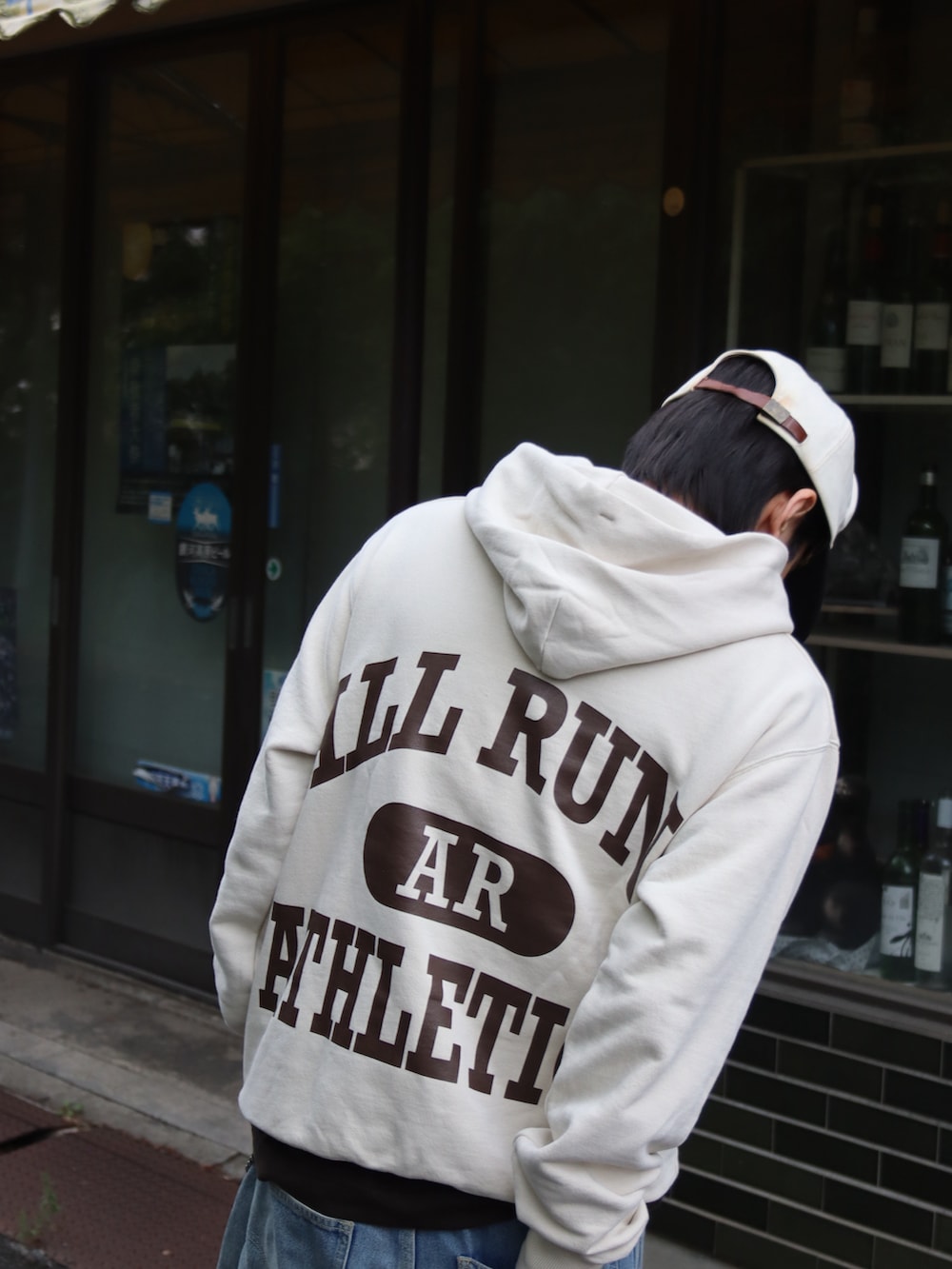 ベージュ系のパーカー、ブラウン系のTシャツ/カットソー、ブルー系のデニムパンツを着用したメンズの秋コーディネートの4枚目の写真