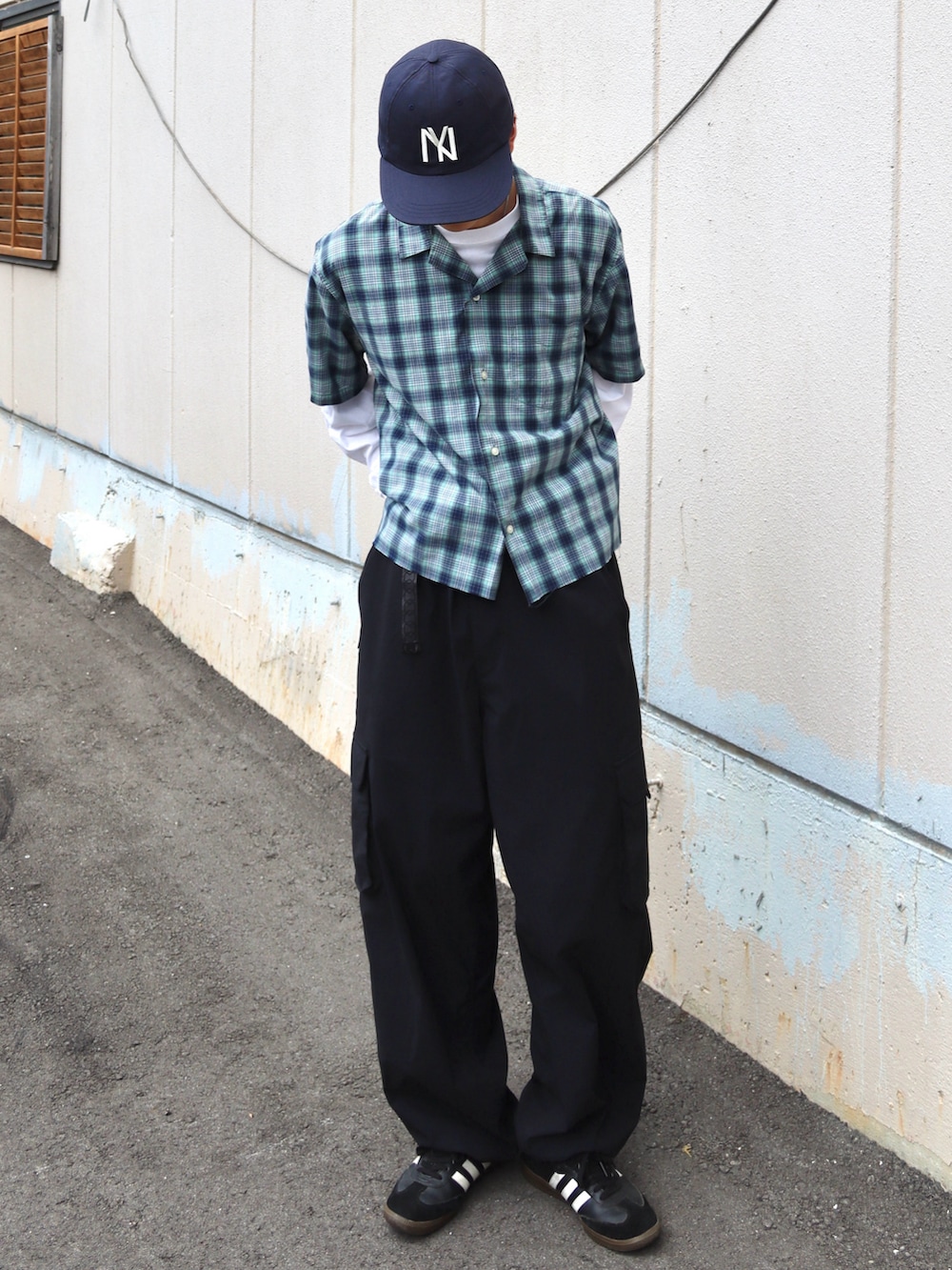 ホワイト系のTシャツ/カットソー、ブラック系のカーゴパンツ、ブラック系のスニーカーを着用したメンズの秋コーディネートの2枚目の写真