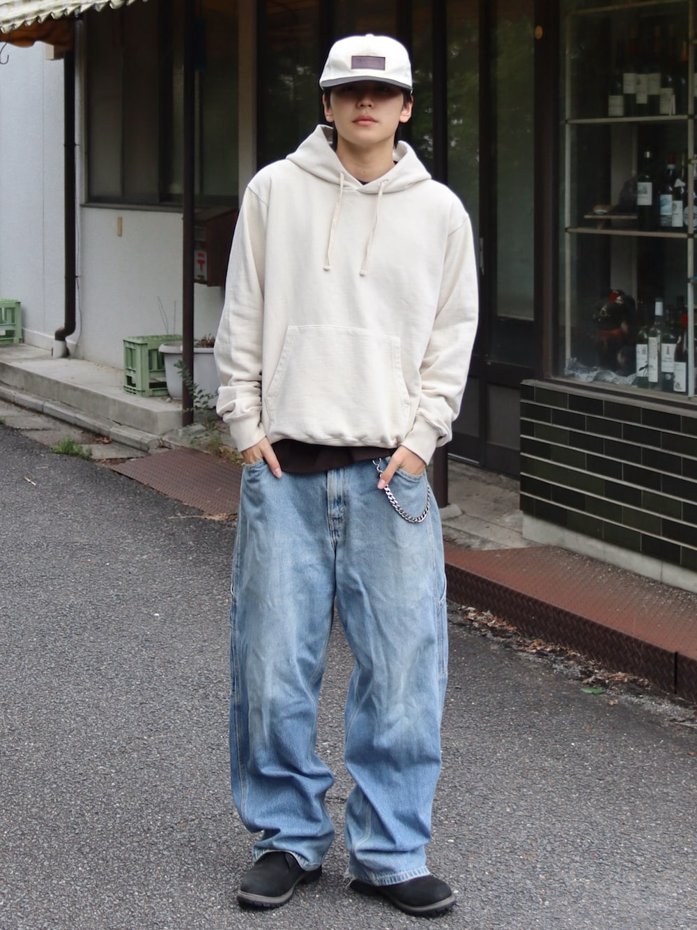 ベージュ系のパーカー、ブラウン系のTシャツ/カットソー、ブルー系のデニムパンツを着用したメンズの秋コーディネートの2枚目の写真