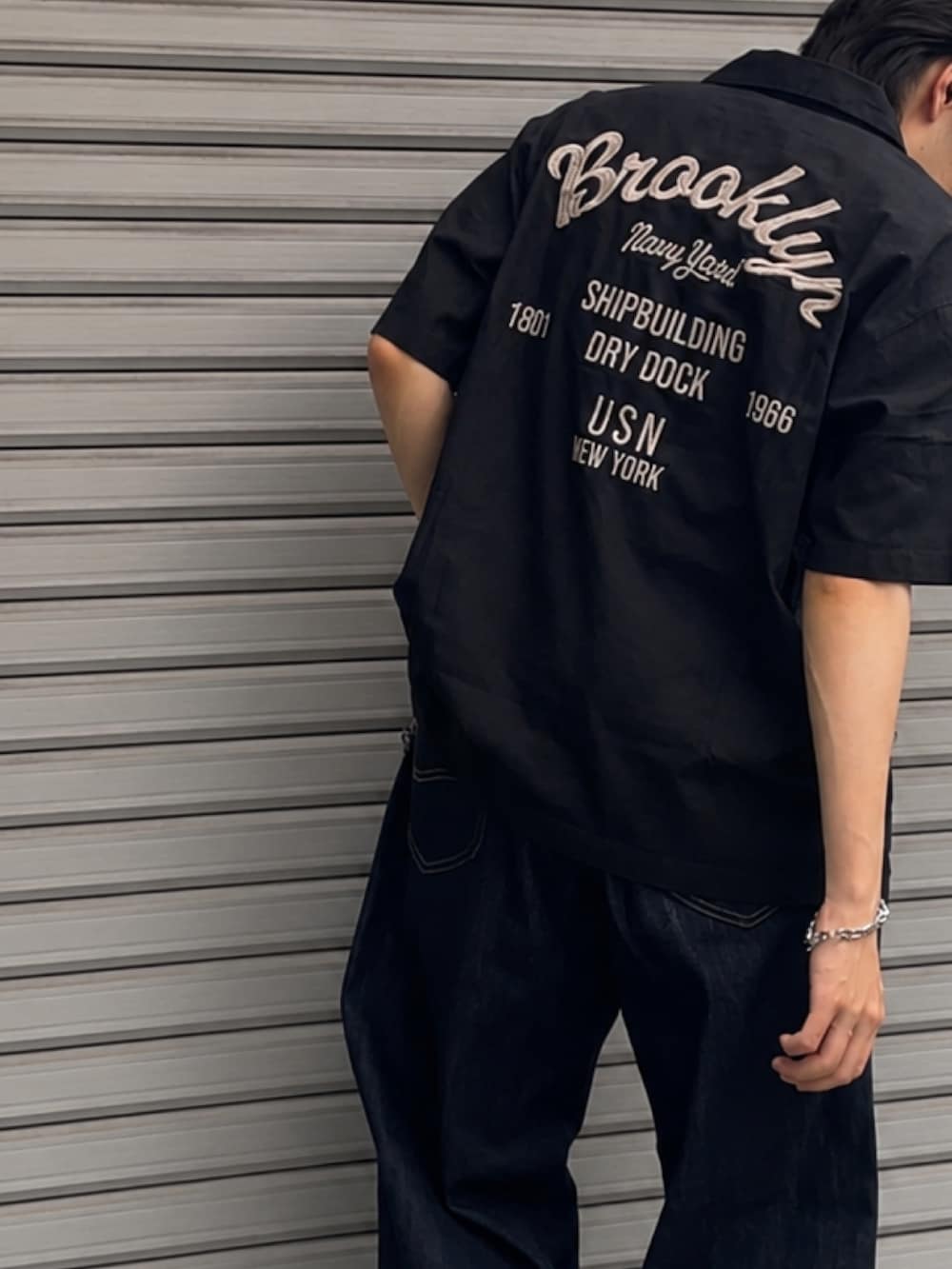 ブルー系のデニムパンツ、ブラック系のシャツ/ブラウス、ブラック系のドレスシューズを着用したメンズの夏コーディネートの3枚目の写真
