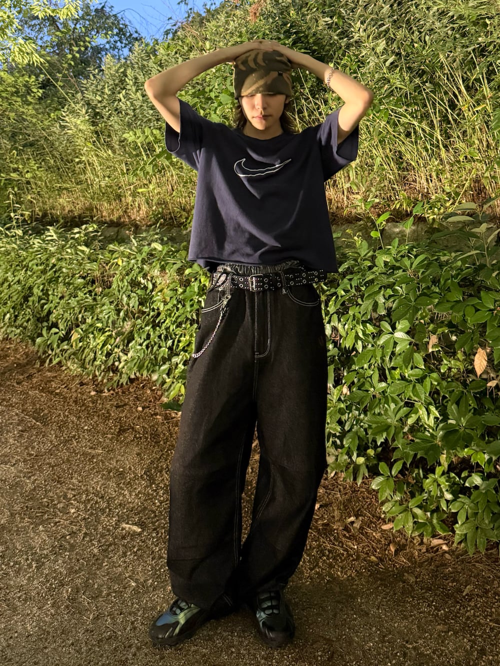 ブラック系のスニーカー、ブルー系のTシャツ/カットソー、ブラック系のデニムパンツを着用したメンズの夏コーディネートの2枚目の写真