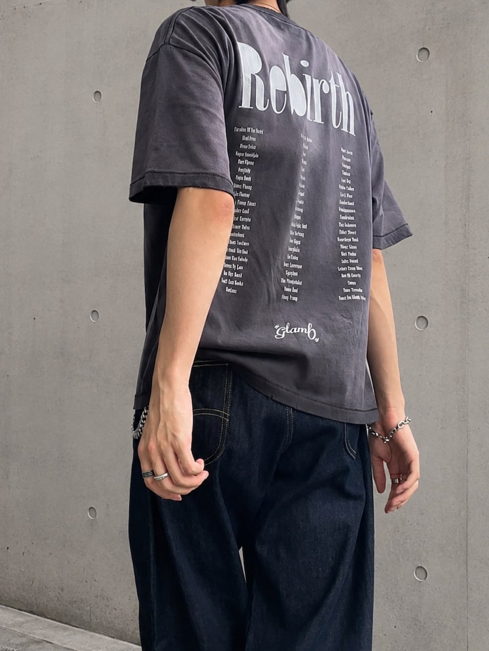 ブラック系のTシャツ/カットソー、ブルー系のデニムパンツ、ブラック系のブーツを着用したメンズの夏コーディネートの3枚目の写真